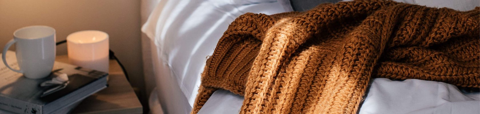 Bett mit Decke und Kaffeetasse