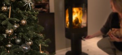 Mädchen, das mit Weihnachtsbaum Holz in den Kamin legt