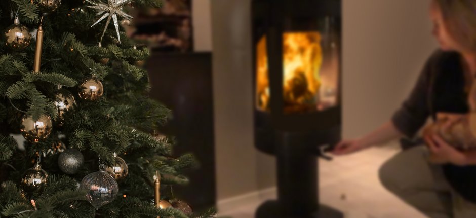 Mädchen, das mit Weihnachtsbaum Holz in den Kamin legt