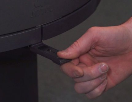 Hand, die die Luftzufuhr im Kamin regelt