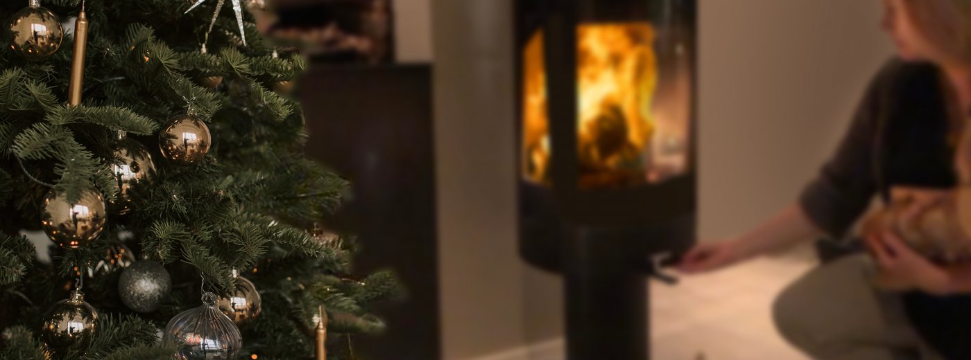 Mädchen, das mit Weihnachtsbaum Holz in den Kamin legt