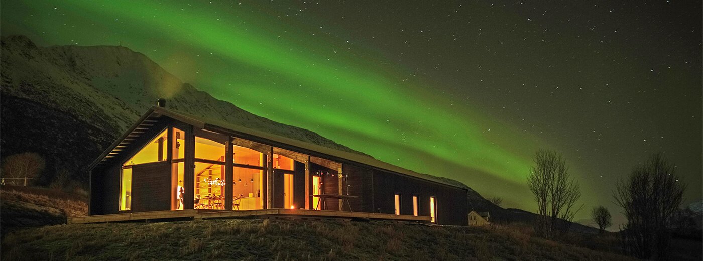 Moderne Hütte am Abend mit Nordlichtern