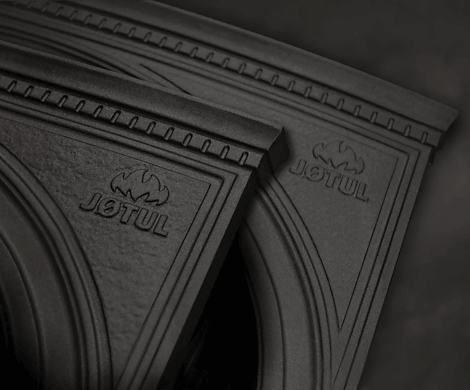 Detailaufnahme von Jøtul-Gusseisenteilen mit geprägtem Logo – robustes Material für langlebige Kaminöfen.