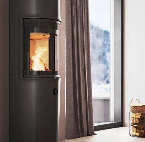 Modernes Zimmer mit großem schwarzen Jøtul F 176-Holzofen, pudervioletten Wänden und Blick auf die verschneiten Berge